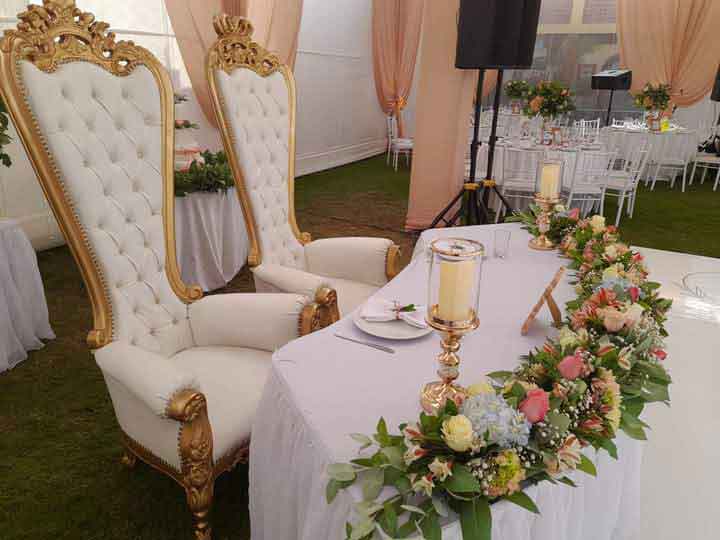Mesa principal y sillas decoradas para novios